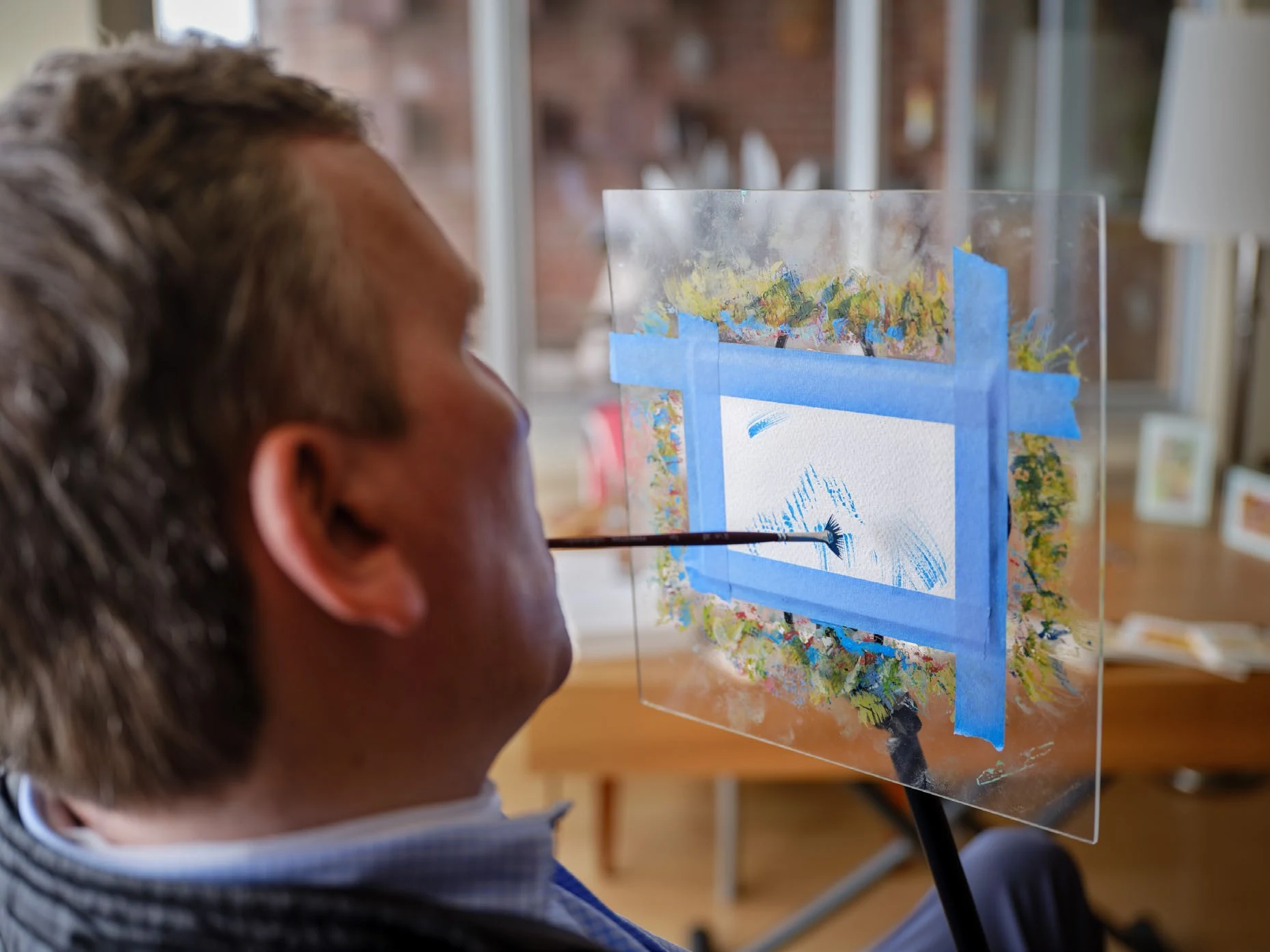 Ned Church painting a small watercolor in his studio